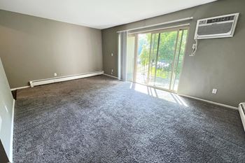 an empty living room with grey carpet and a sliding glass door at Crown Pointe Apartments, Kentucky, 41014